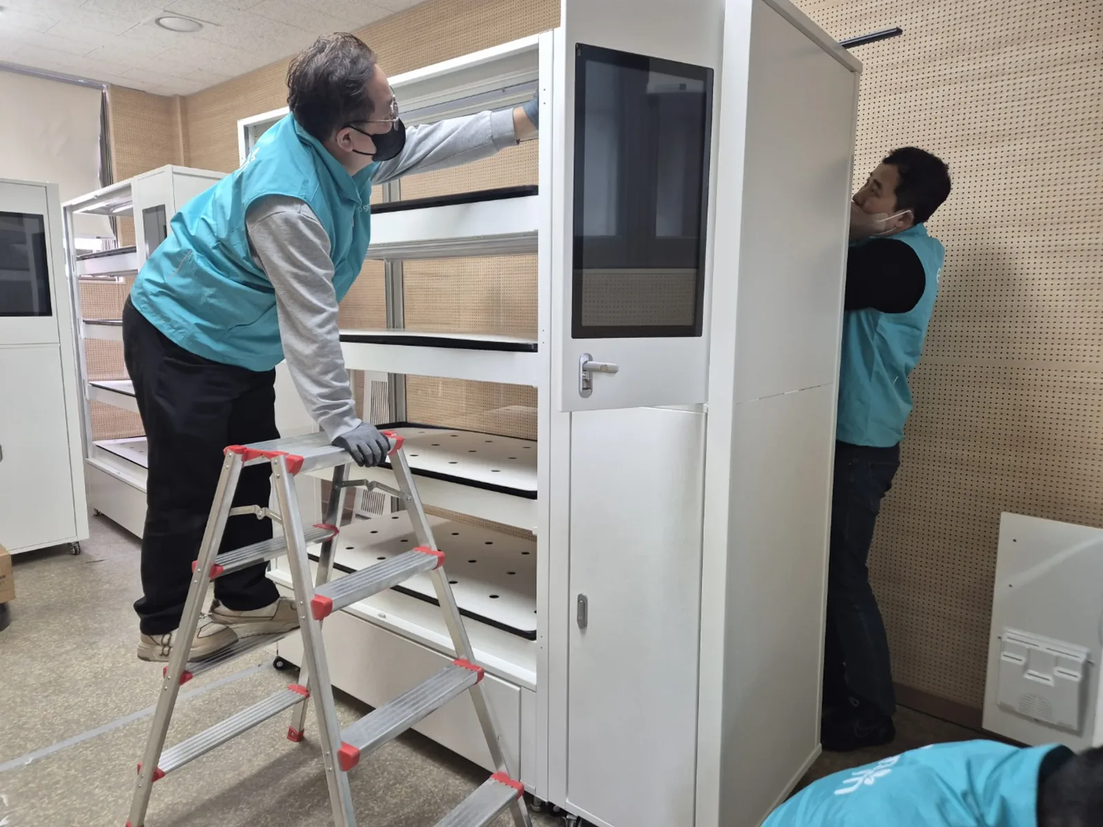 전남과학대학교 스마트가든 사무실 재배 유닛을 사다리 위에서 설치하는 모습